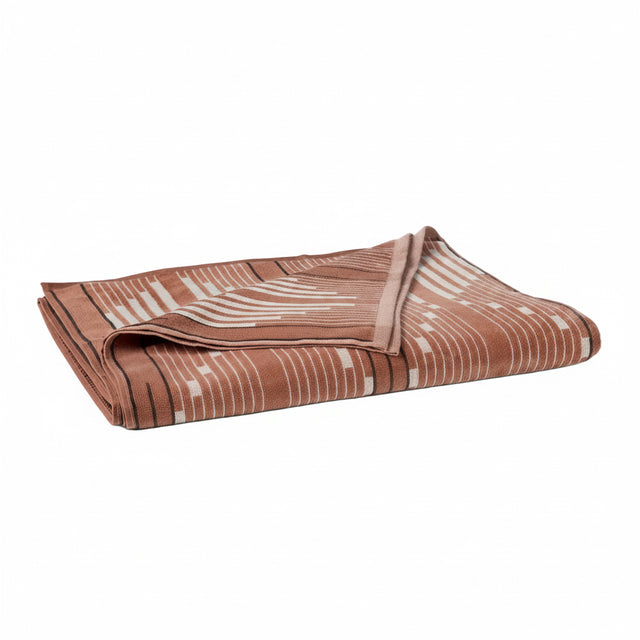 MORELIA ORGANIC BEACH TOWEL | Folded brown beach towel with graphic pattern