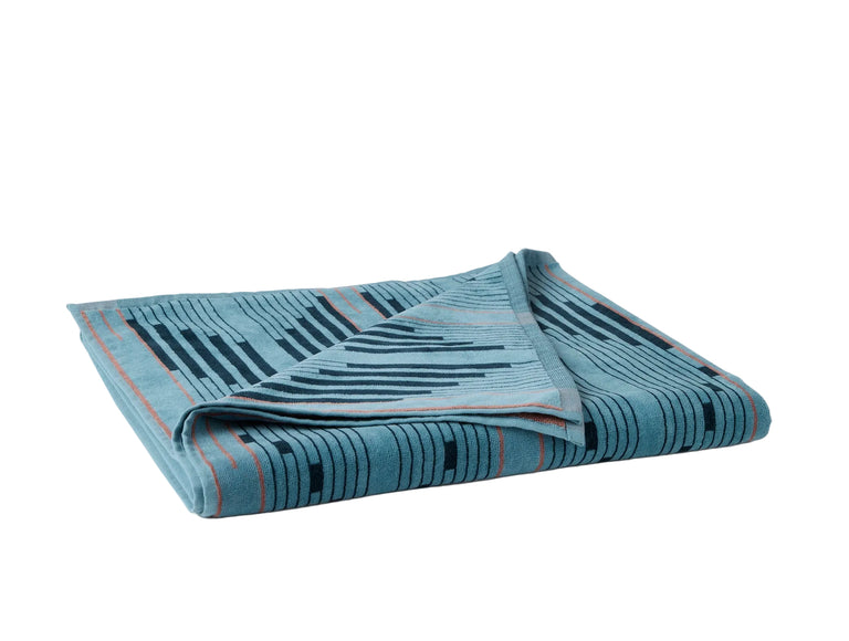 MORELIA ORGANIC BEACH TOWEL | Folded blue beach towel with graphic pattern